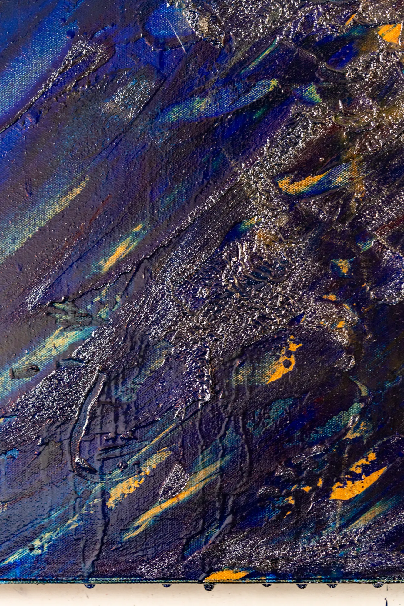 Upright close view of yellow and pale green streaks running diagonally through blue, with a silver ridge above them.