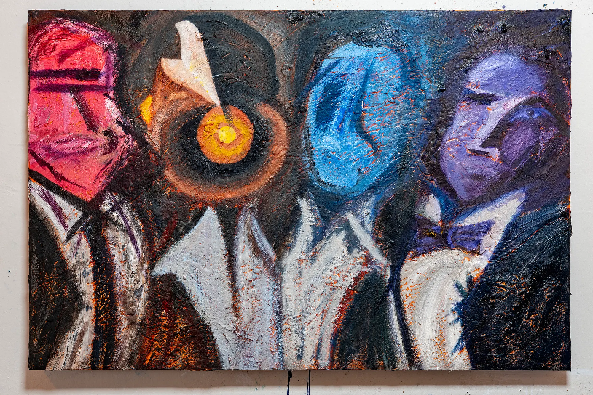 After the Ceremony on a studio wall: four figures in white shirts and dark formalwear, their heads rendered as a red-pink mask, an orange ringed eye, a blue head and a violet head.