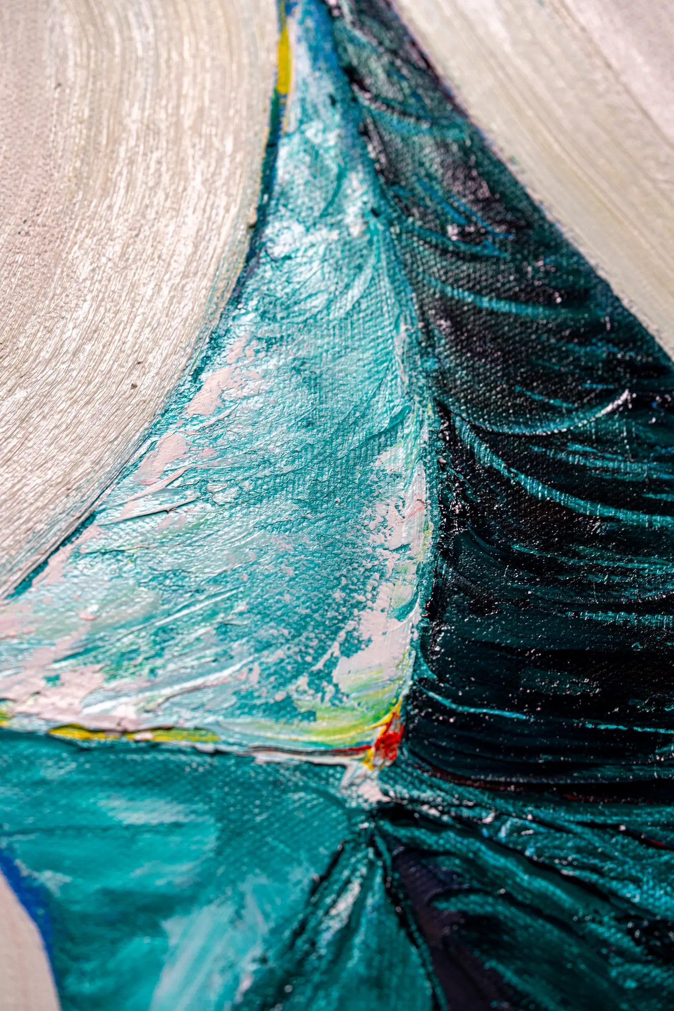 Upright close view of the teal shape, pale ribs on one side and deep green-black on the other meeting at a sharp fold.