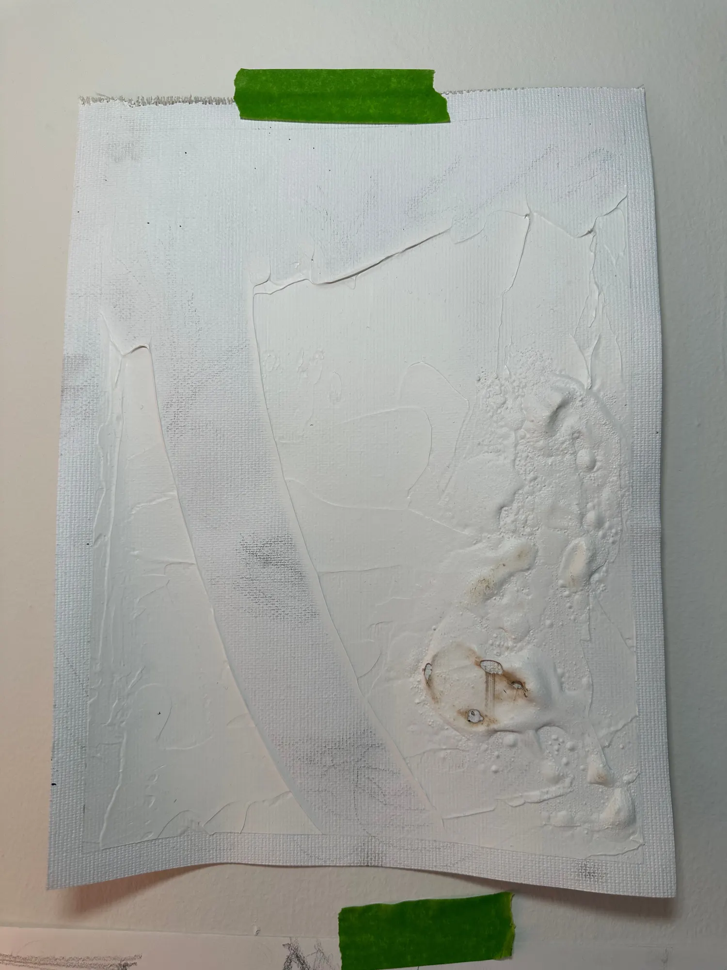 A white textured test panel with a scorched, blistered brown patch where a heat gun and an open flame were used on the surface.