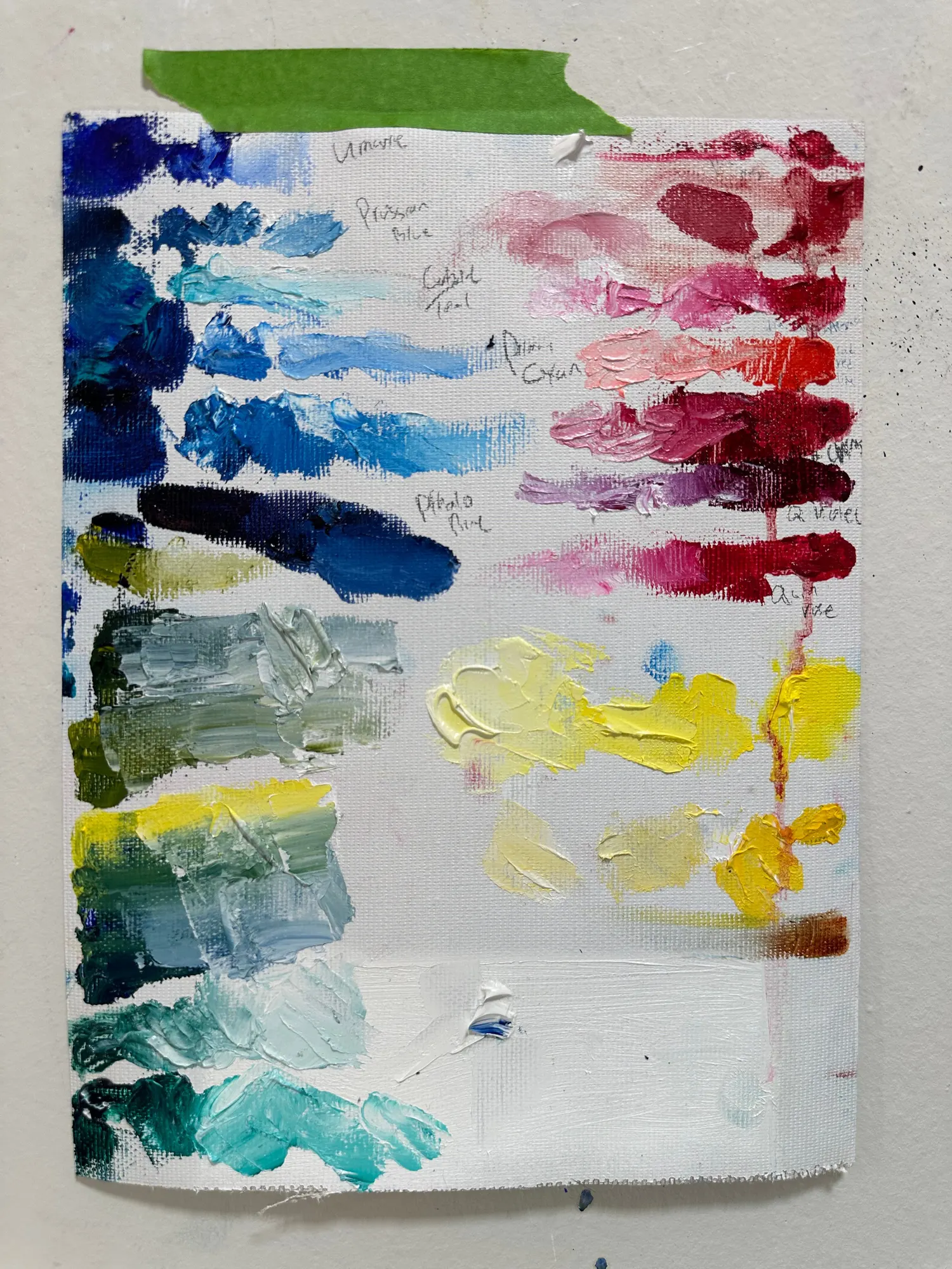 A canvas pad swatched with twenty-four oil paints, reds and pinks in the upper rows, yellows and blues below, each colour repeated underneath cut with white.